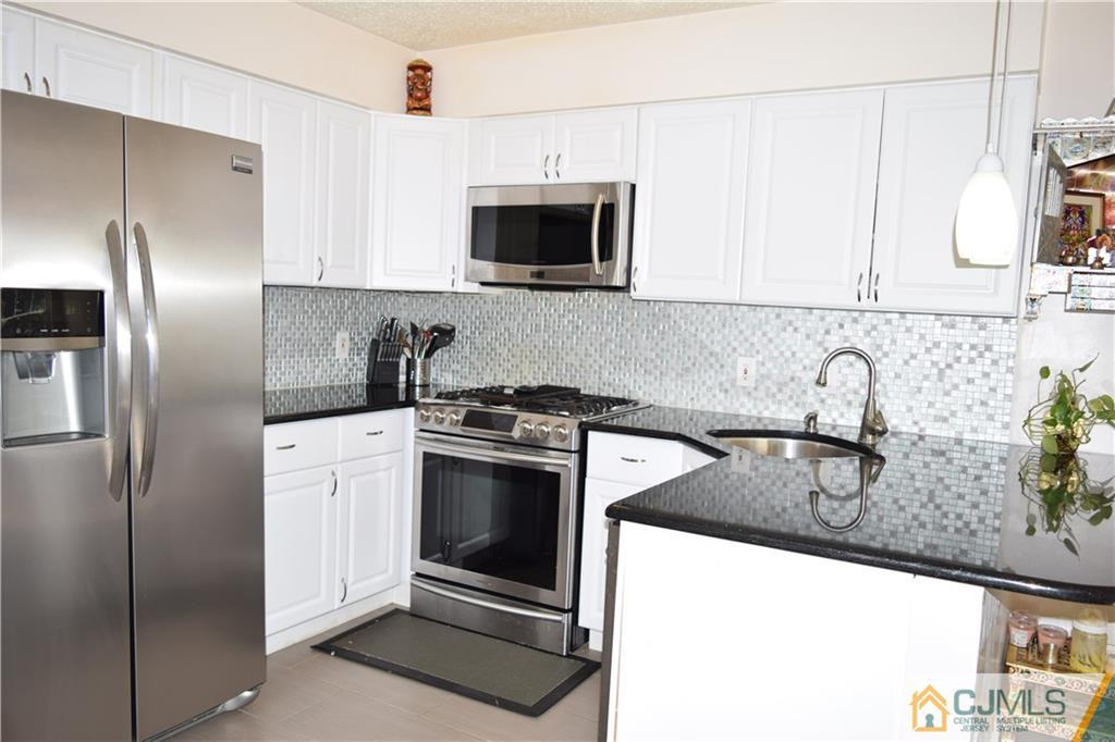 338 Lunar Road Piscataway, NJ 08854 - Photo 2 of 20 a kitchen with stainless steel appliances granite countertop a sink and a refrigerator