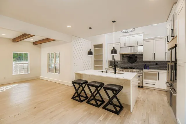 a kitchen with stainless steel appliances kitchen island granite countertop a refrigerator and a stove top oven