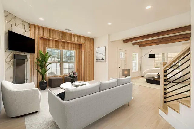 a living room with furniture a flat screen tv and a large window