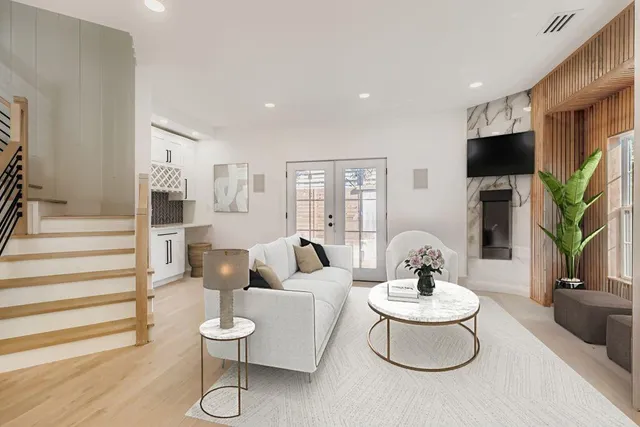 a living room with furniture a flat screen tv and a table