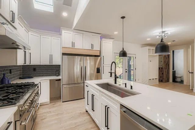 a kitchen with refrigerator a sink and a stove