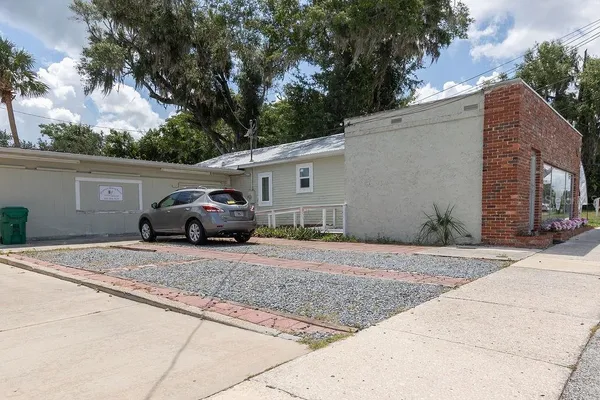 a white house that has a tree in front of it