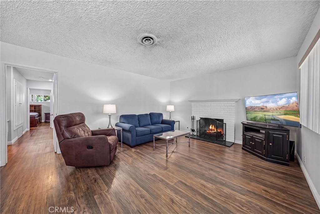29078 Bradley Road Menifee, CA 92586 - Photo 9 of 42 a living room with furniture flat screen tv and a fireplace