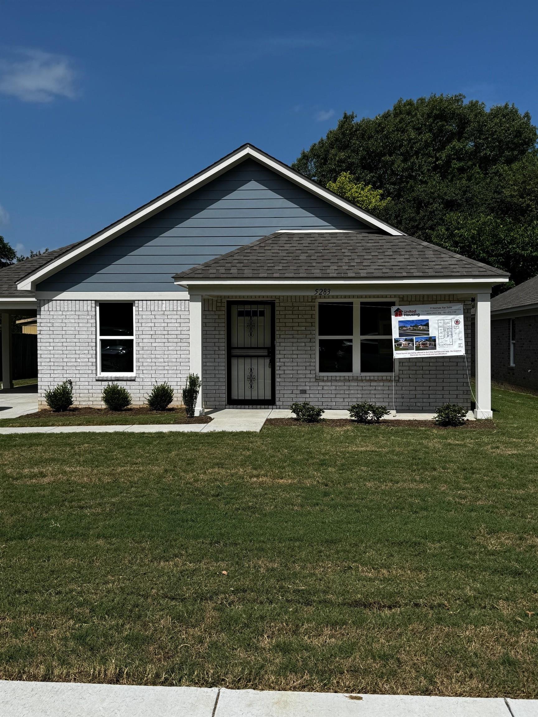 Ranch-style home with a front yard, brick siding, roof with shingles, and covered porch