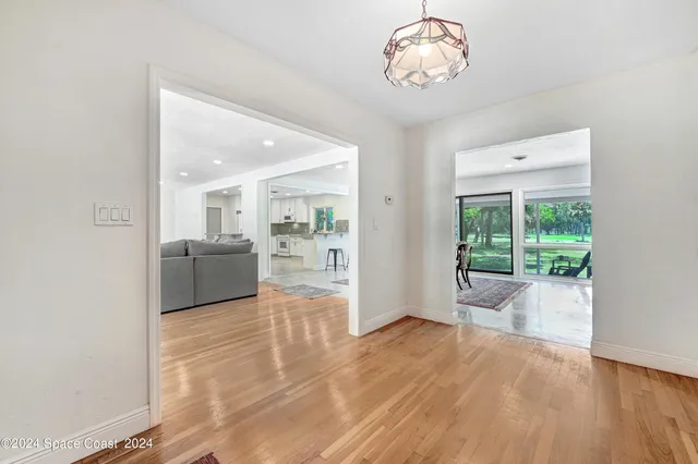 a view of a big room with wooden floor and a kitchen