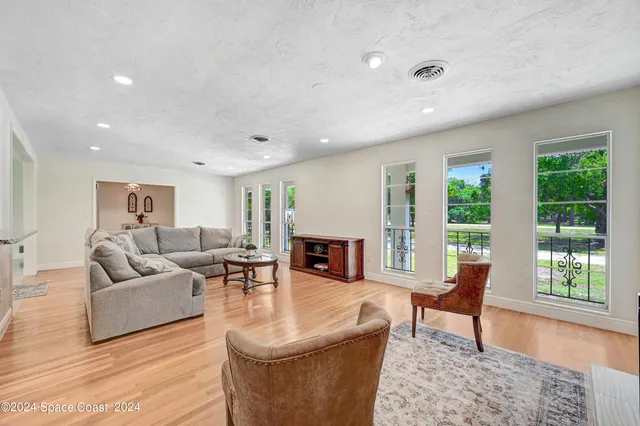 a living room with fireplace furniture and a large window