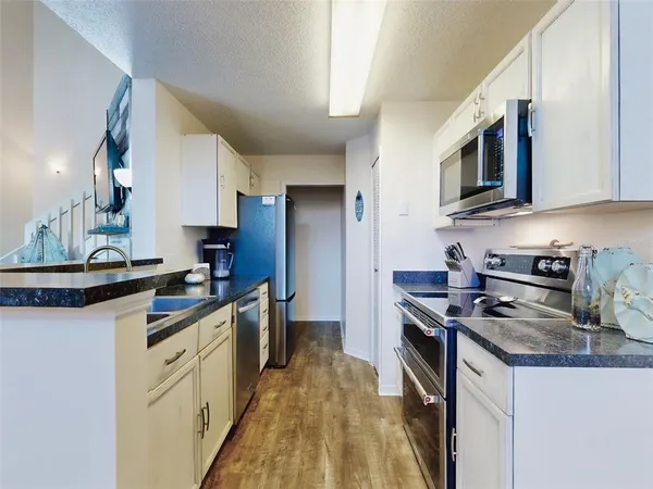 a kitchen with stainless steel appliances granite countertop a stove top oven a sink a microwave and refrigerator