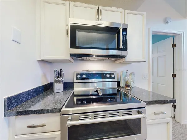 a kitchen with stainless steel appliances granite countertop a stove microwave and sink