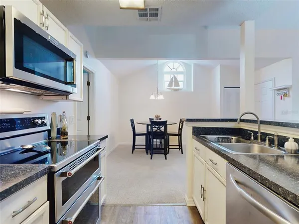 a kitchen with stainless steel appliances granite countertop a sink and a microwave