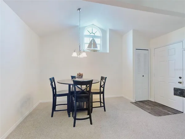 a view of a dining room with furniture and a chandelier