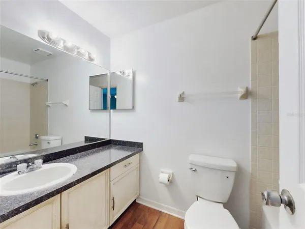 a bathroom with a granite countertop sink a large mirror and a toilet