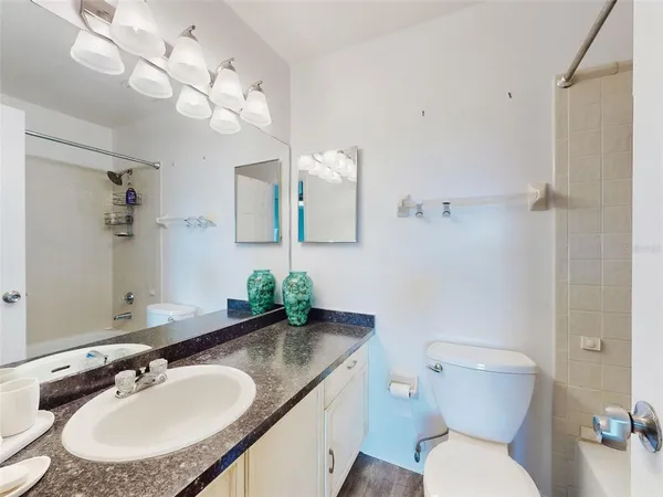 a bathroom with a granite countertop toilet sink and mirror