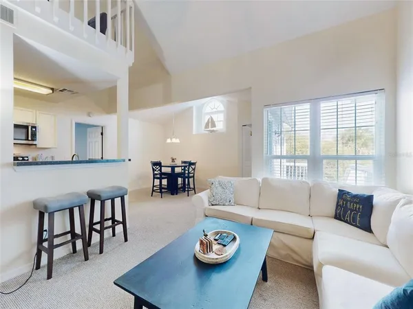 a living room with furniture and view of kitchen