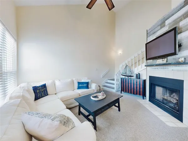 a living room with furniture a flat screen tv and a fireplace