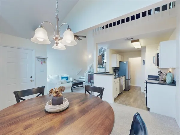 a living room with furniture kitchen and a chandelier