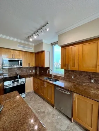 a kitchen with stainless steel appliances granite countertop sink stove top oven and cabinets