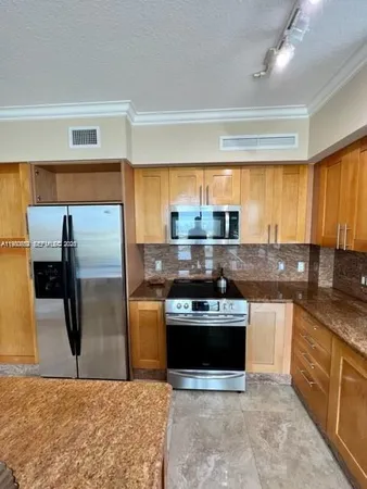 a kitchen with stainless steel appliances granite countertop a stove a refrigerator and a sink