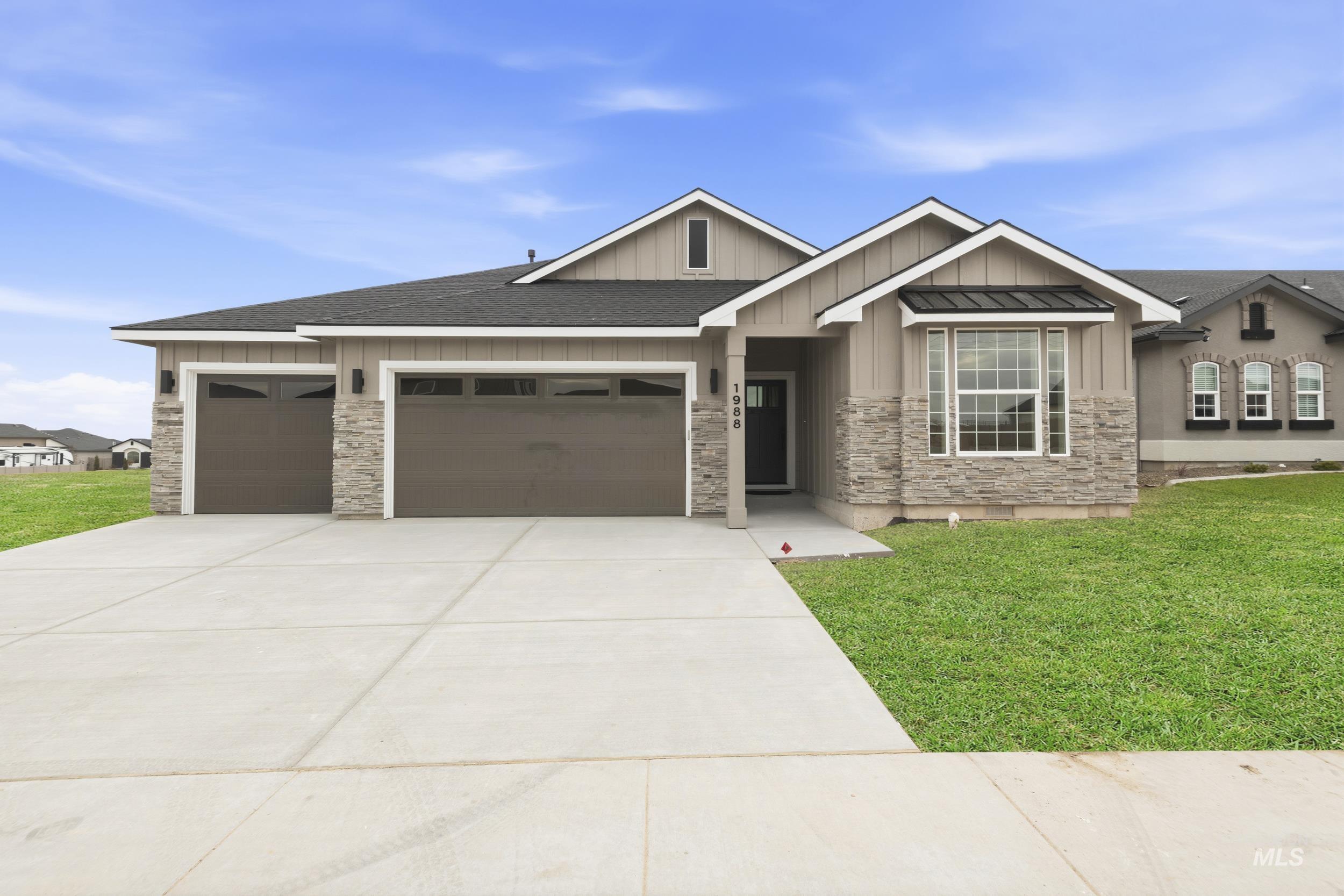 1988 West Bittern Street Nampa, ID 83686 - Photo 2 of 34 View of front of property featuring board and batten siding, a front lawn, roof with shingles, and stone siding