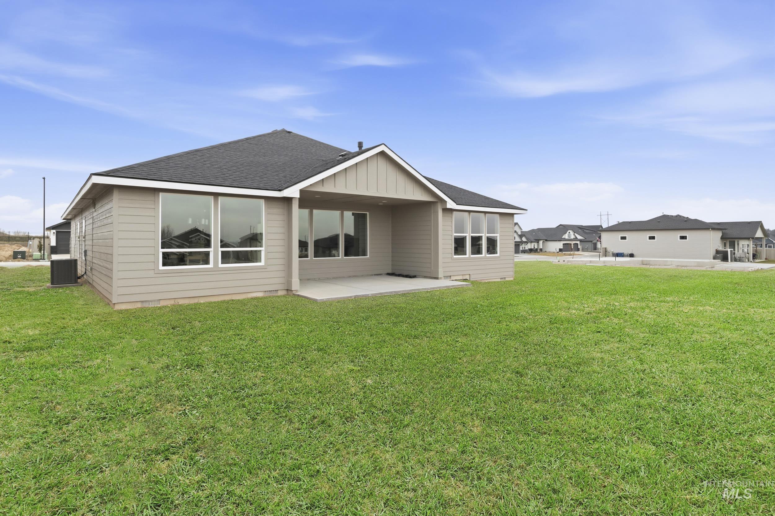 1988 West Bittern Street Nampa, ID 83686 - Photo 33 of 34 Rear view of house featuring a patio, roof with shingles, a lawn, and board and batten siding