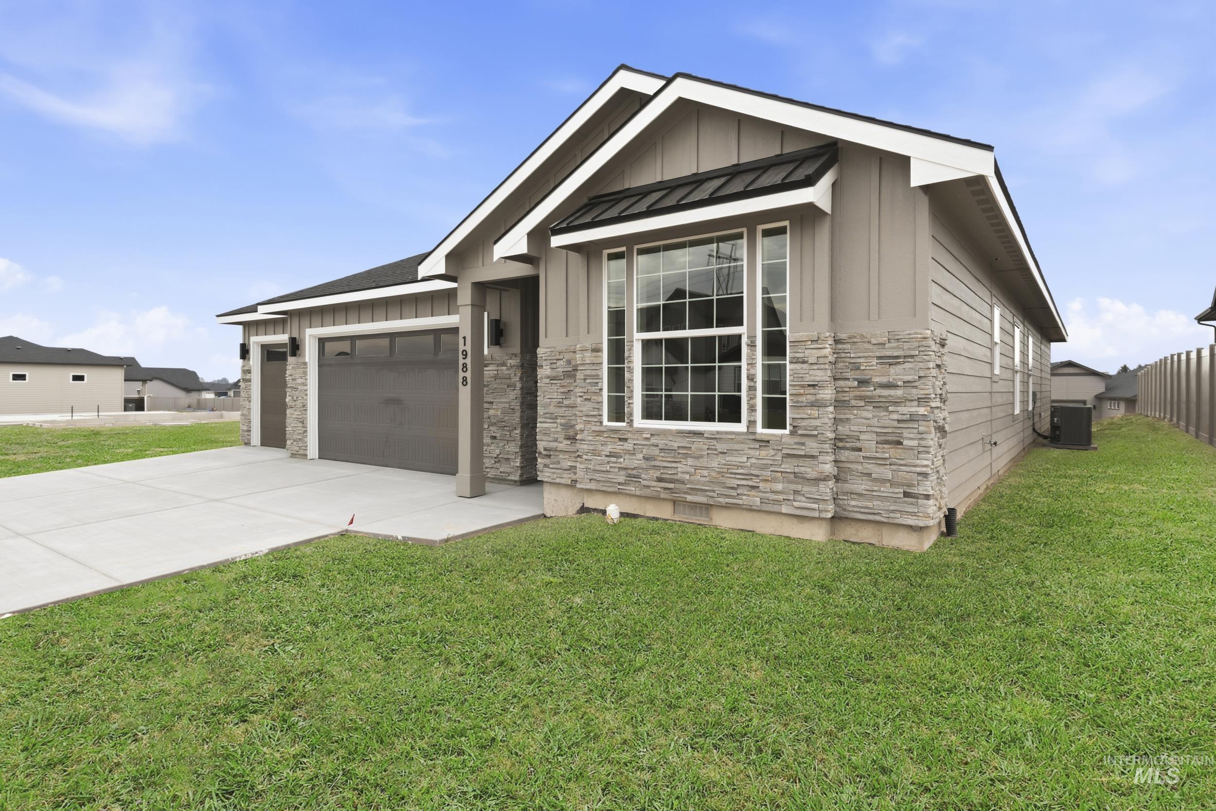 1988 West Bittern Street Nampa, ID 83686 - Photo 4 of 34 View of front of house with board and batten siding, a garage, stone siding, concrete driveway, and a standing seam roof
