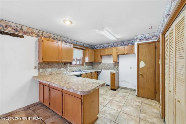 a kitchen with a sink a counter top space and stainless steel appliances