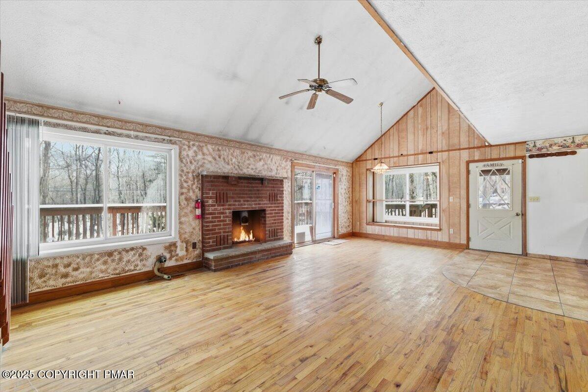 5695 Decker Road Bushkill, PA 18324 - Photo 7 of 29 an empty room with windows fireplace and wooden floor