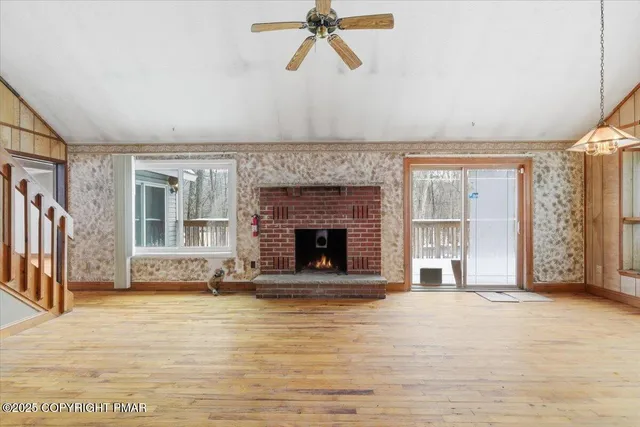 a view of an empty room with a fireplace and a window