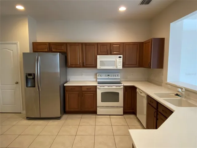 a kitchen with a stove a refrigerator and a sink
