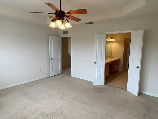 a view of an empty room with a chandelier fan