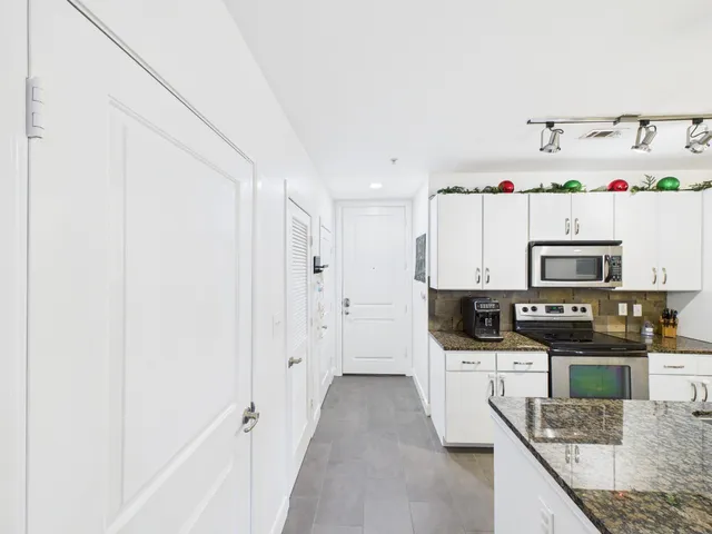 a view of kitchen with refrigerator stove and cabinets