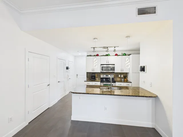 a kitchen with stainless steel appliances granite countertop a sink stove and refrigerator