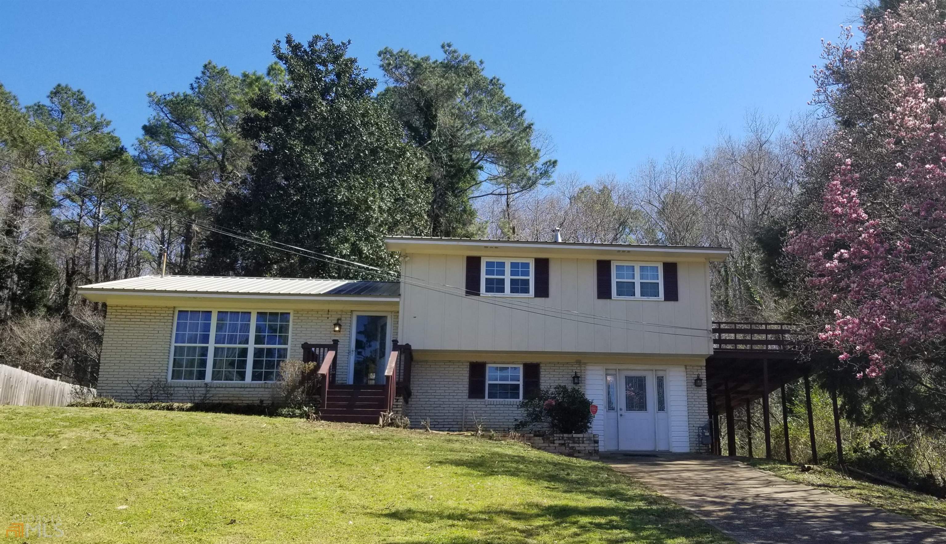 a view of a house with floor to ceiling windows and a yard