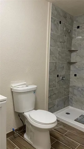 a white toilet sitting next to a bath tub and shower