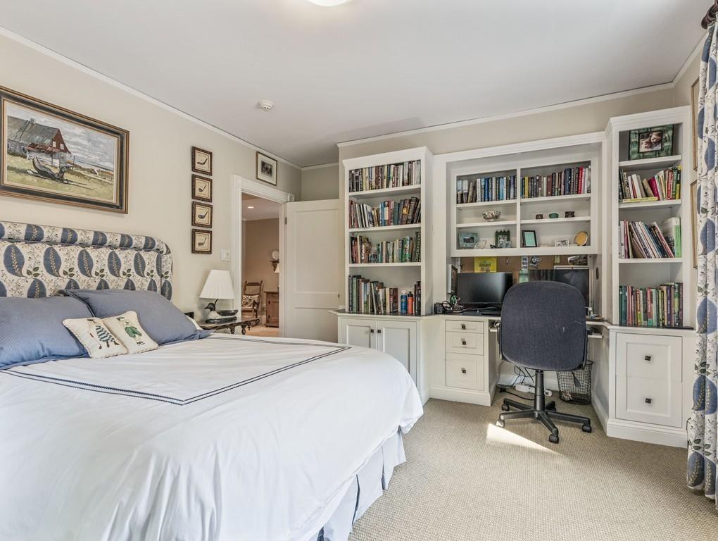 101 Abbott Road Wellesley, MA 02481 - Photo 29 of 38 a bedroom with a bed and a bookshelf with wooden floor