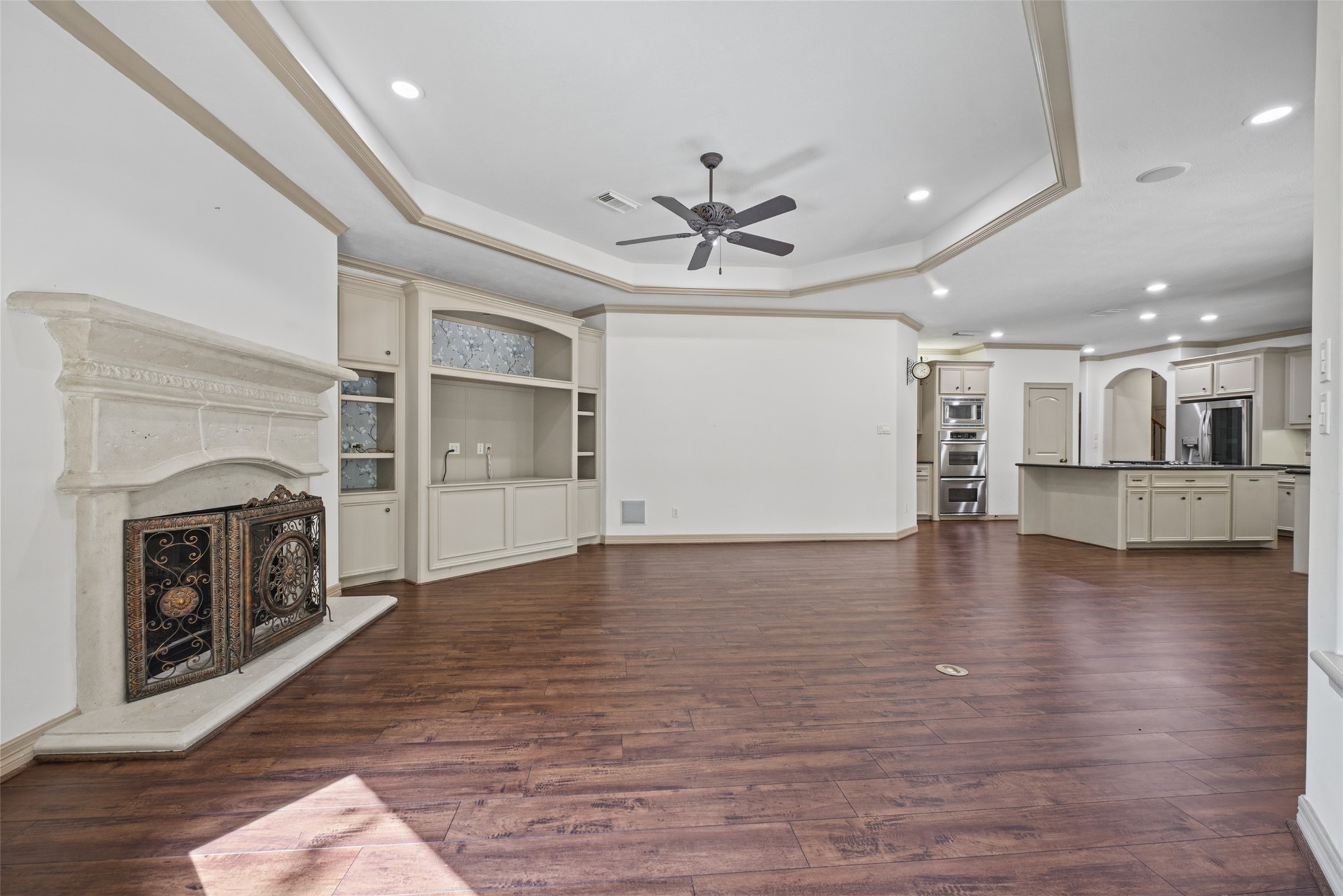 25119 Arcane Court Spring, TX 77389 - Photo 11 of 50 The fireplace is flanked by a built-in entertainment center featuring open display shelving and generous cabinetry. Designed with both style and function in mind, it provides a dedicated space for your television and electronics, while offering plenty of room to showcase favorite artwork, photos, books, and collectibles. Concealed cabinetry keeps everyday items neatly tucked away for a clean, organized look.