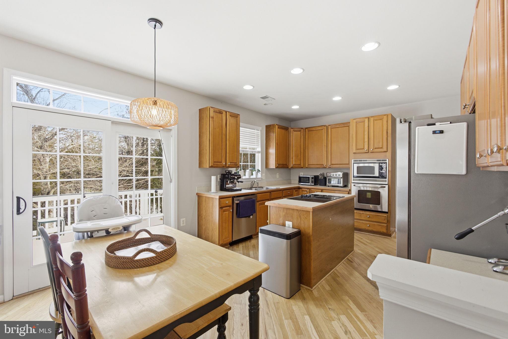 13119 Bigleaf Maple Court Gainesville, VA 20155 - Photo 11 of 36 a kitchen with a sink a kitchen island and stainless steel appliances