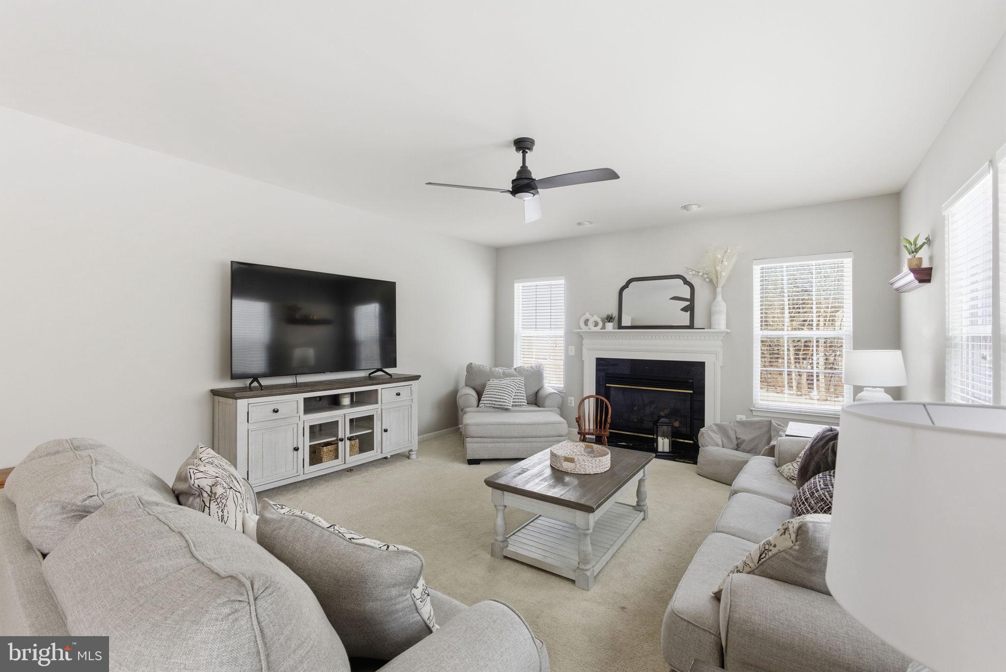 13119 Bigleaf Maple Court Gainesville, VA 20155 - Photo 5 of 36 a living room with furniture a fireplace and a flat screen tv
