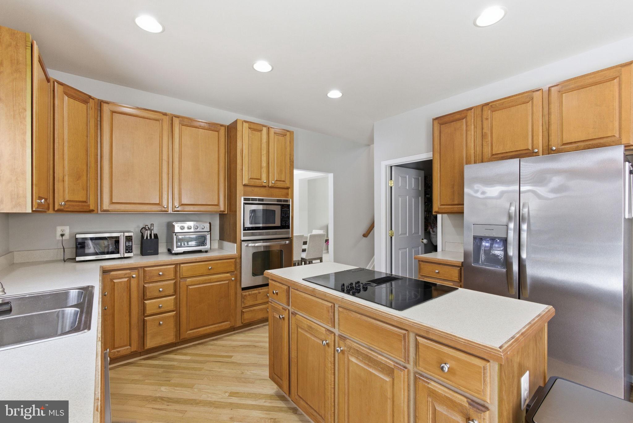 13119 Bigleaf Maple Court Gainesville, VA 20155 - Photo 10 of 36 a kitchen with stainless steel appliances granite countertop a sink stove and refrigerator