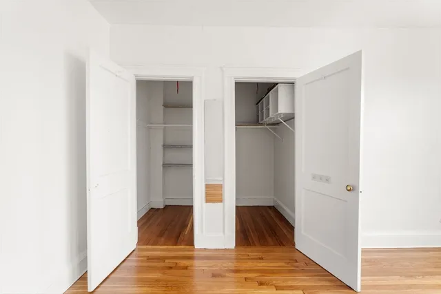 a view of a livingroom with wooden floor and a hallway