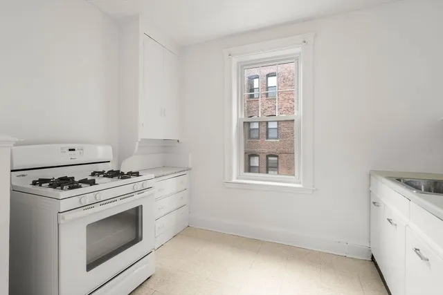 a stove top oven sitting inside of a kitchen