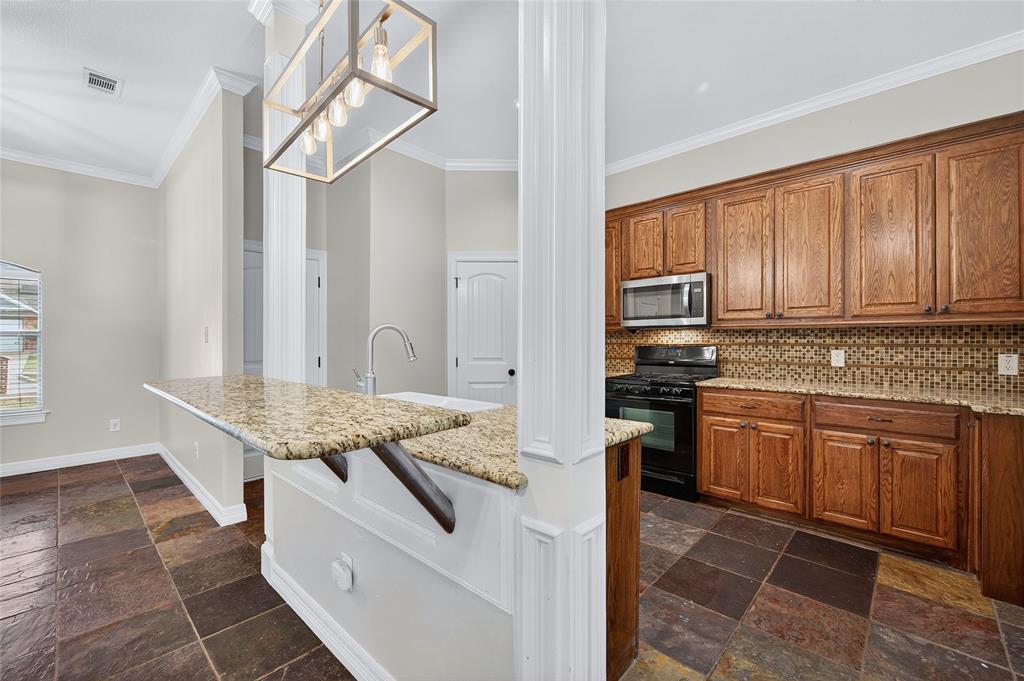 4814 Hilre Drive Sherman, TX 75092 - Photo 8 of 27 a kitchen with stainless steel appliances granite countertop a stove refrigerator and cabinets