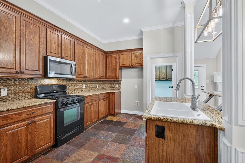 4814 Hilre Drive Sherman, TX 75092 - Photo 9 of 27 a kitchen with stainless steel appliances granite countertop a stove sink and cabinets