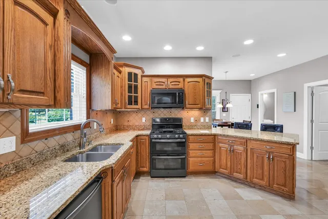 a view of kitchen with stainless steel appliances wooden floor dining table and chairs