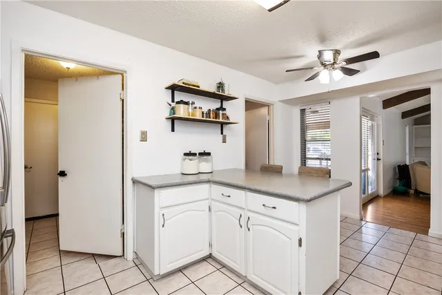 a kitchen with white cabinets and chandelier