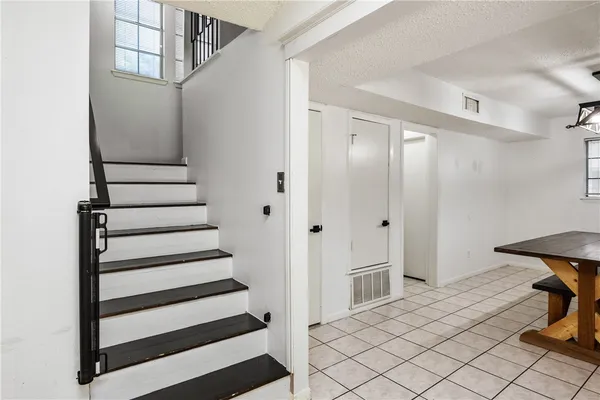 a view of a hallway with wooden cabinets and staircase