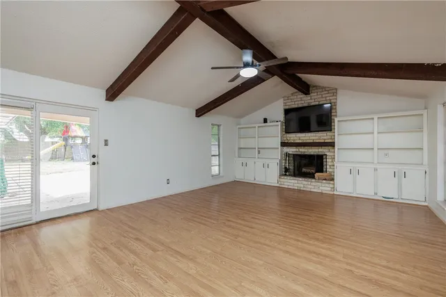 a view of empty room with wooden floor and windows