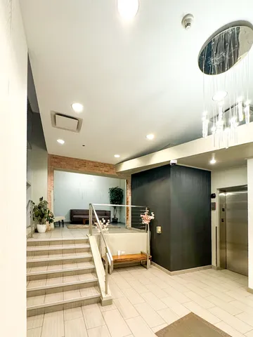 a room with stainless steel appliances kitchen island granite countertop a sink and a refrigerator