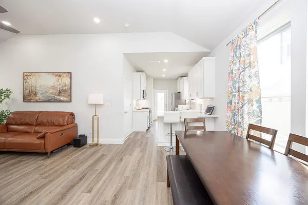 a kitchen with kitchen island granite countertop a sink cabinets and wooden floor