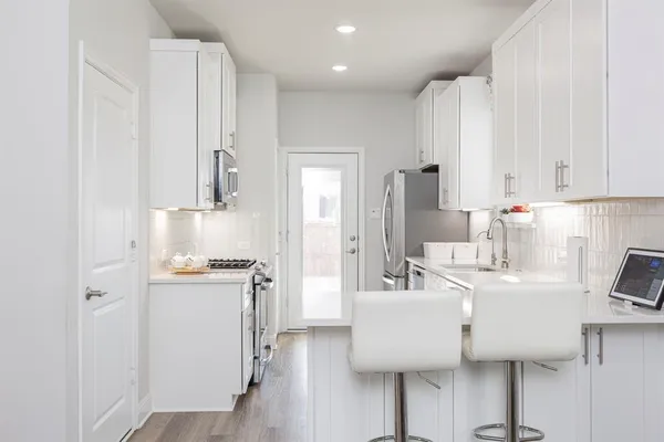 a kitchen with stainless steel appliances granite countertop a sink a stove and a refrigerator