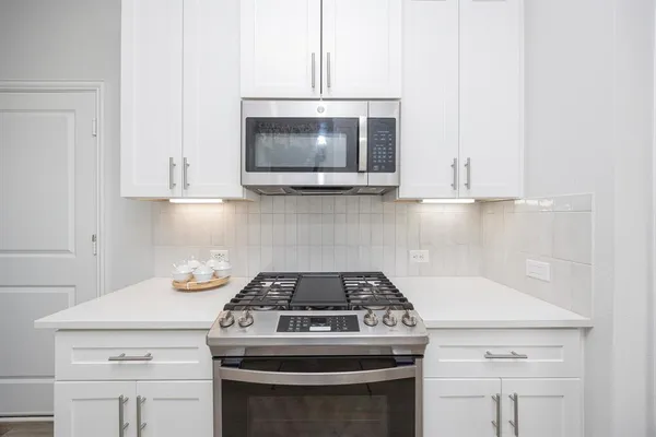 a kitchen with stainless steel appliances a sink stove and microwave
